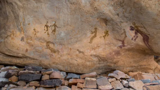 Prehistoric rock paintings of human figures in red ochre on a sandstone overhang at Tassili n'Ajjer, Algeria