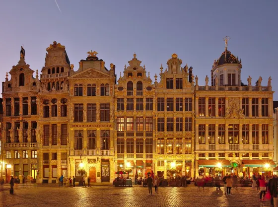 The ornate gilded guildhouses of the Grand-Place in Brussels, lit up at twilight