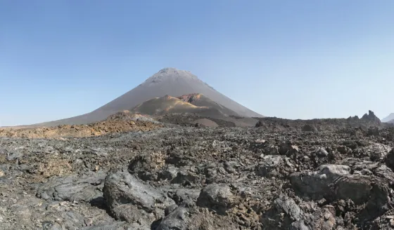 The bare cone of the Pico do Fogo volcano rising above a dark lava field on Fogo island, Cabo Verde