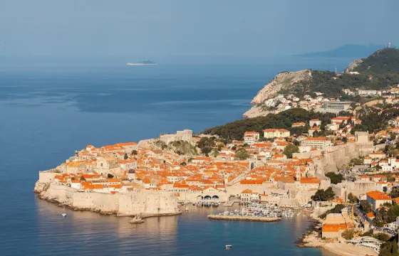 Dubrovnik's walled old town of orange-roofed houses on a headland jutting into the blue Adriatic Sea