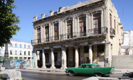 A classic 1950s American car parked on a colorful street in Havana, Cuba