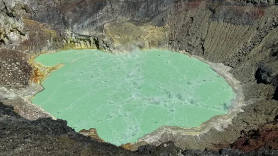 A pale green crater lake held inside the steep ash walls of the Santa Ana volcano, El Salvador