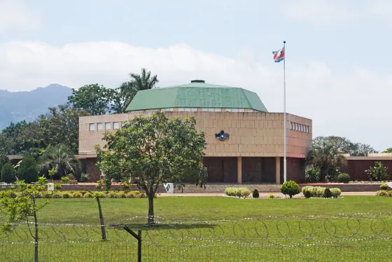 The low, round, green-roofed Parliament building of Eswatini at Lobamba, with mountains behind