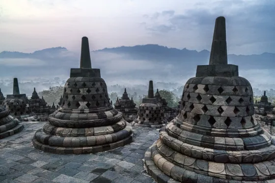 Stone stupas atop Borobudur temple at sunrise, Java, Indonesia