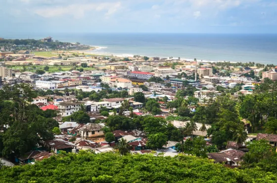 Rooftops of Monrovia spreading between green hills and the Atlantic shore, Liberia