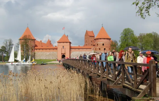 The red brick towers of Trakai Island Castle across the lake, reached by a wooden footbridge, Lithuania