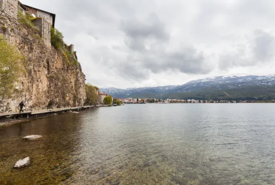 Clear water along the rocky, cliff-backed shore of Lake Ohrid, North Macedonia