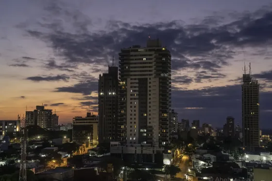 Apartment towers and low rooftops of Asuncion silhouetted against a purple dusk sky, Paraguay