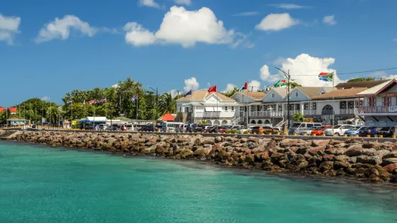 The ferry pier at Charlestown on Nevis, with turquoise water in the foreground and low colourful buildings behind