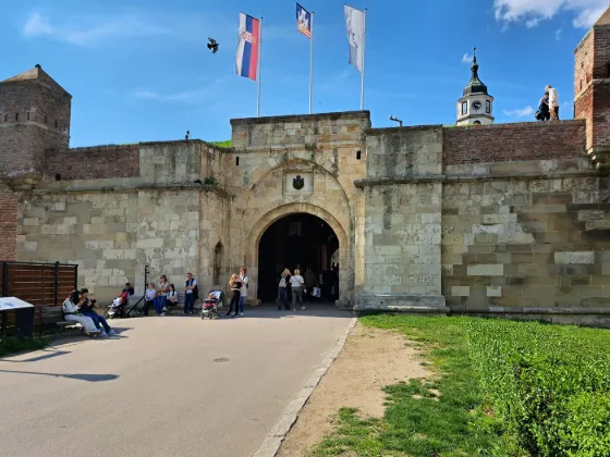 The arched stone gateway of Belgrade Fortress, with flags above and people on the path in front