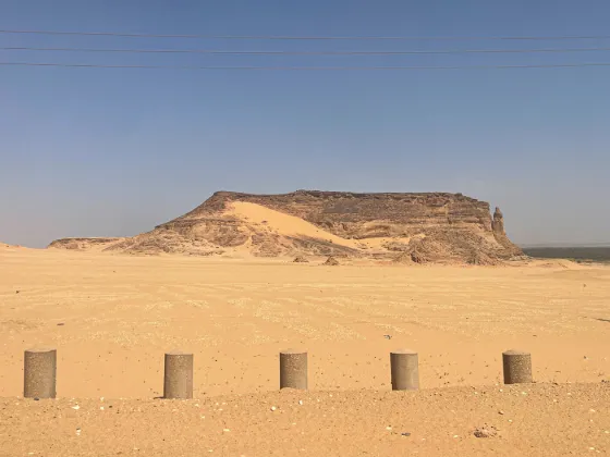 The flat-topped sandstone butte of Jebel Barkal rising from desert sand, a sacred site of the Kingdom of Kush