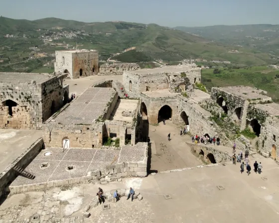 The concentric stone walls and towers of the crusader castle Krak des Chevaliers seen from above, Syria