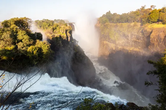 Water pouring over the lip of Victoria Falls into the gorge, throwing up heavy spray